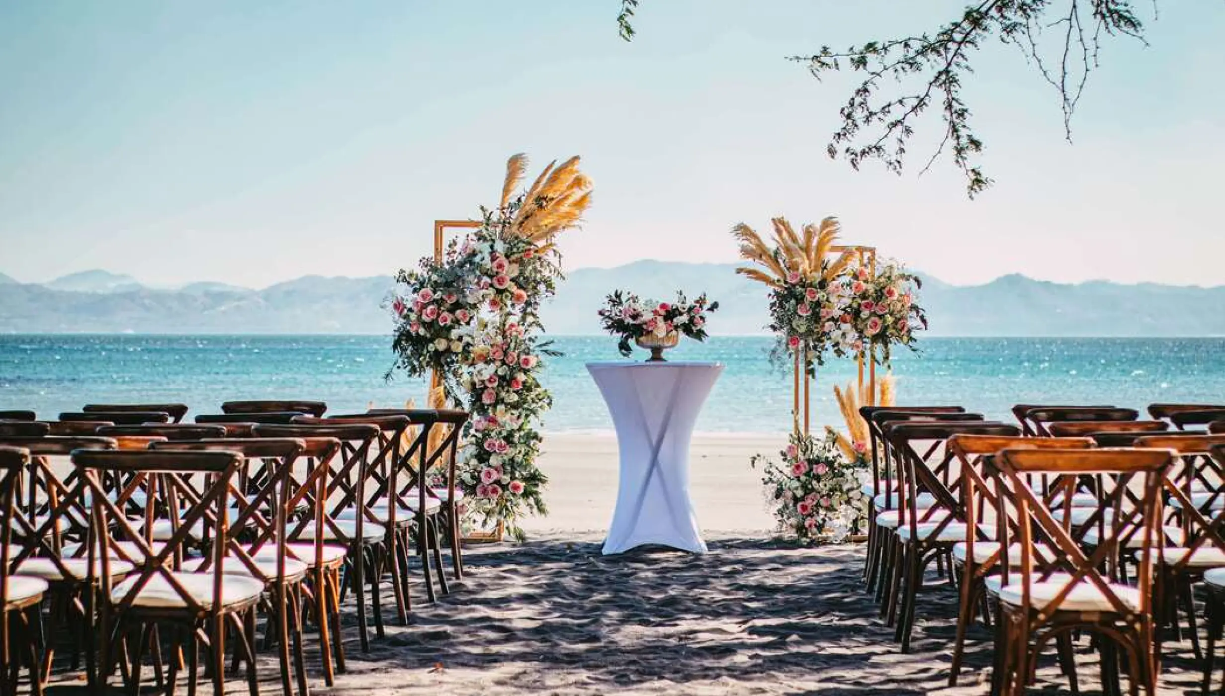 Beachfront wedding ceremony with wooden cross-back chairs at Planet Hollywood Costa Rica, Papagayo