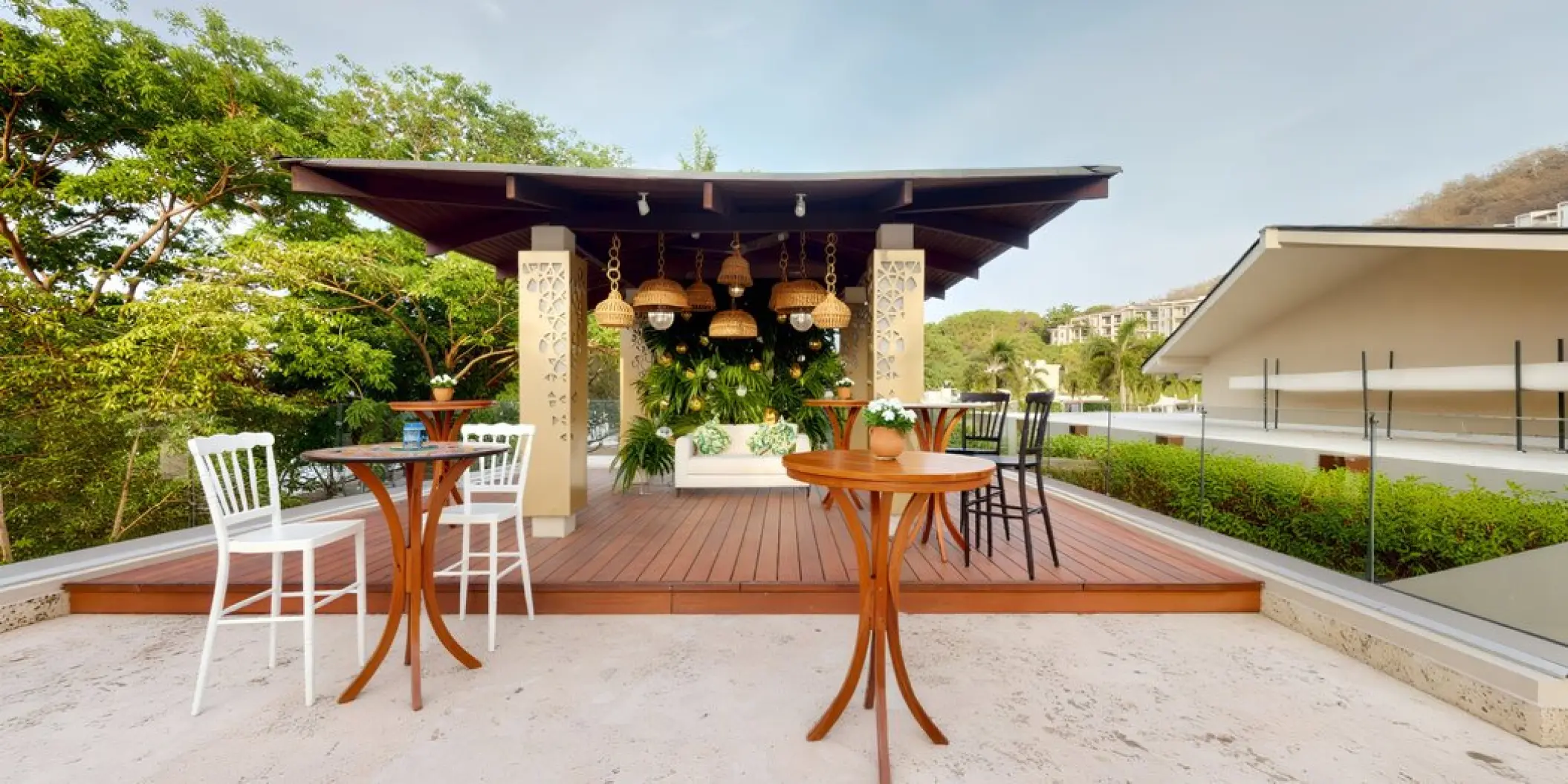 Terrace wedding reception setup with wooden cocktail tables and a covered lounge at Planet Hollywood Costa Rica