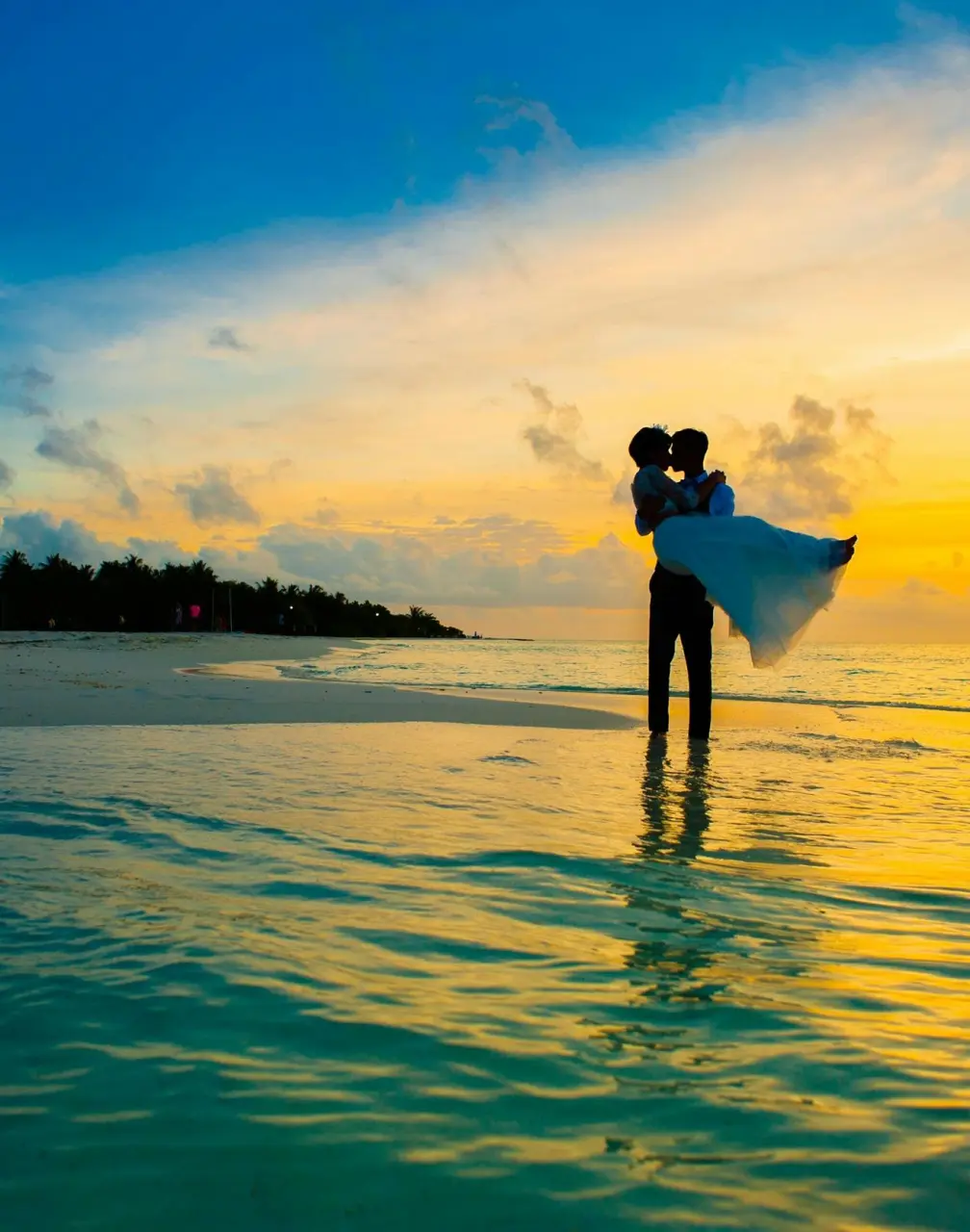 Silhouette of a groom lifting the bride on the beach at sunset, Royalton Antigua
