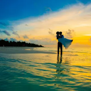 Silhouette of a groom lifting the bride on the beach at sunset, Royalton Antigua