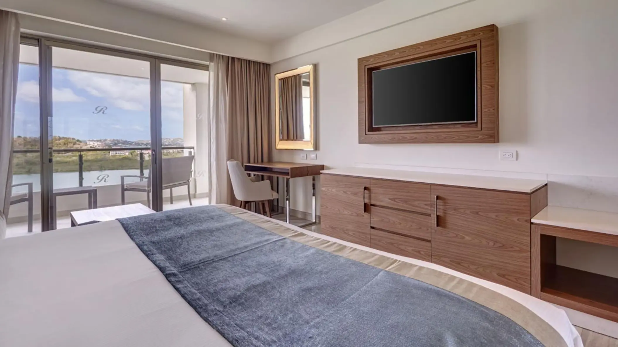 Royalton Antigua oceanfront suite with balcony and modern wood furnishings, Five Islands Village