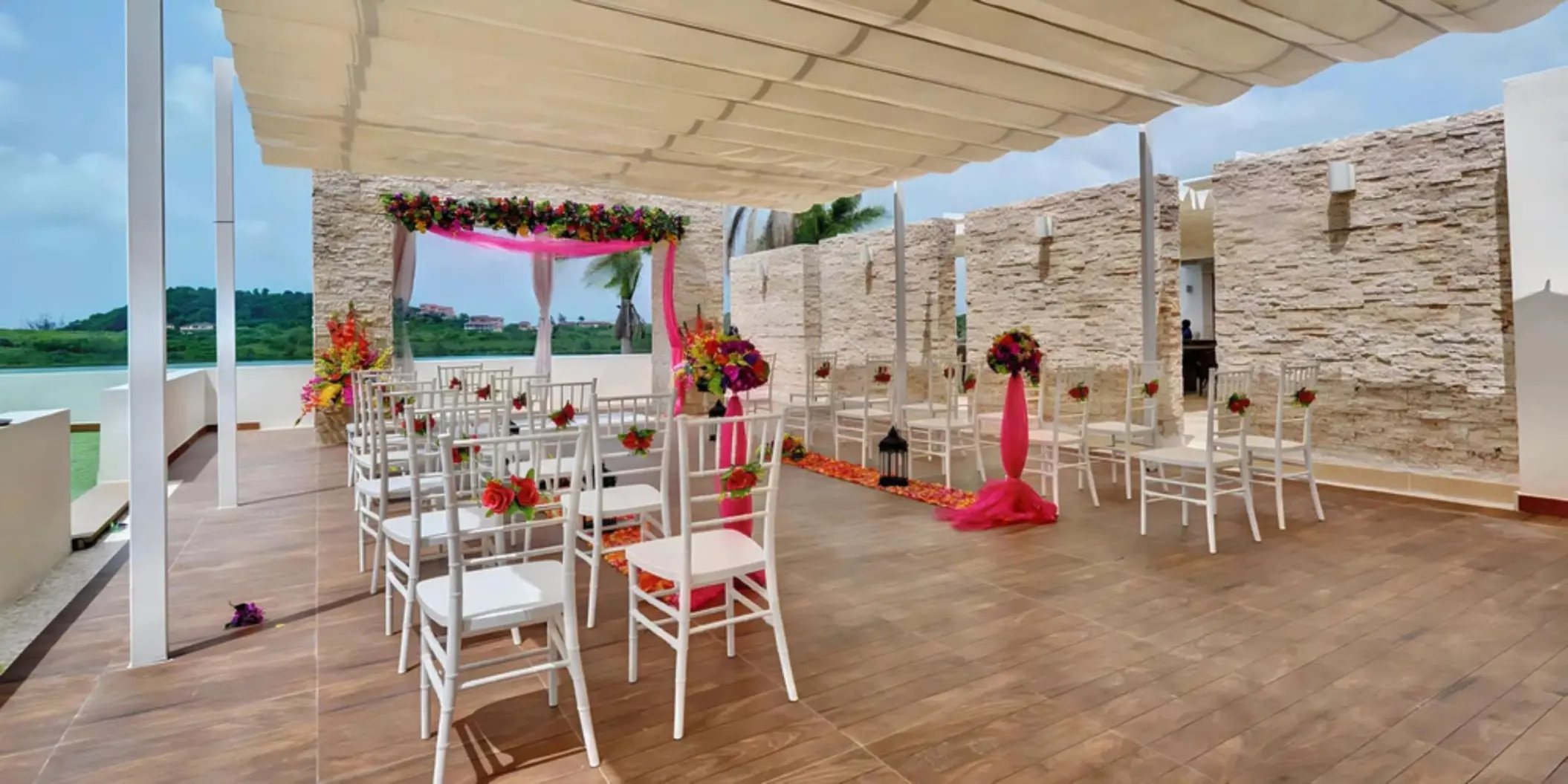Sky wedding ceremony terrace with white chairs and pink floral decor at Royalton Antigua, Five Islands Village