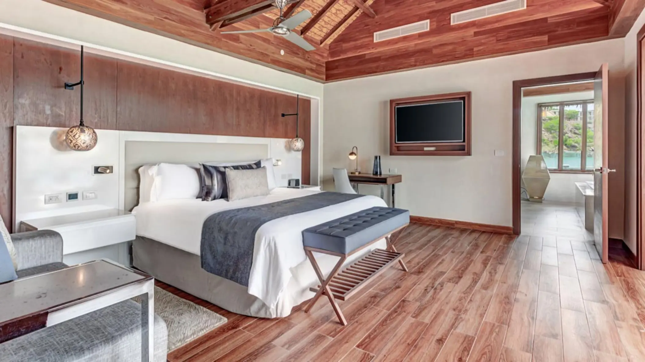 Suite with a king bed and wood ceiling at Royalton Antigua, Five Islands Village