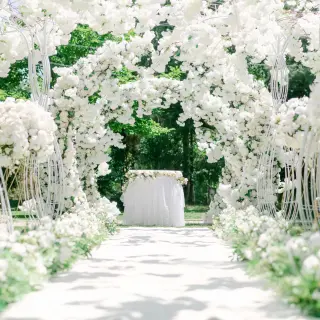 Outdoor wedding ceremony with white floral arches and gold chairs at Royalton Antigua, Five Islands Village