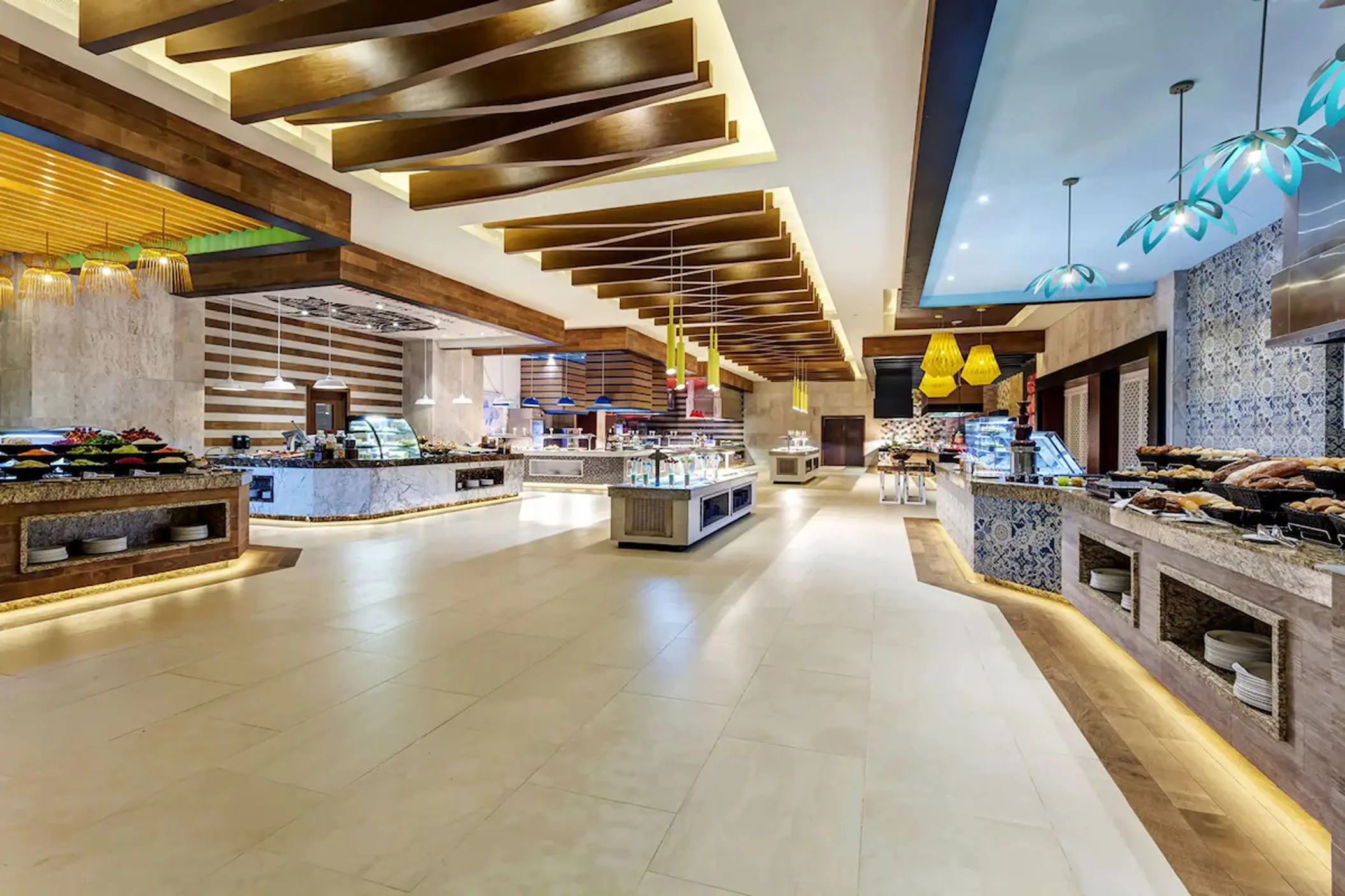 Buffet restaurant food stations with modern wooden ceiling beams at Royalton Bavaro, Punta Cana