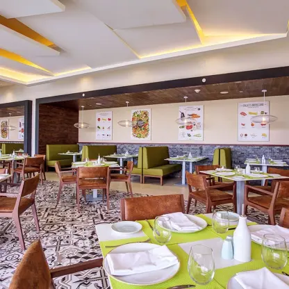 Grazie Italian Trattoria with set tables and green booth seating at Royalton Bavaro, Punta Cana