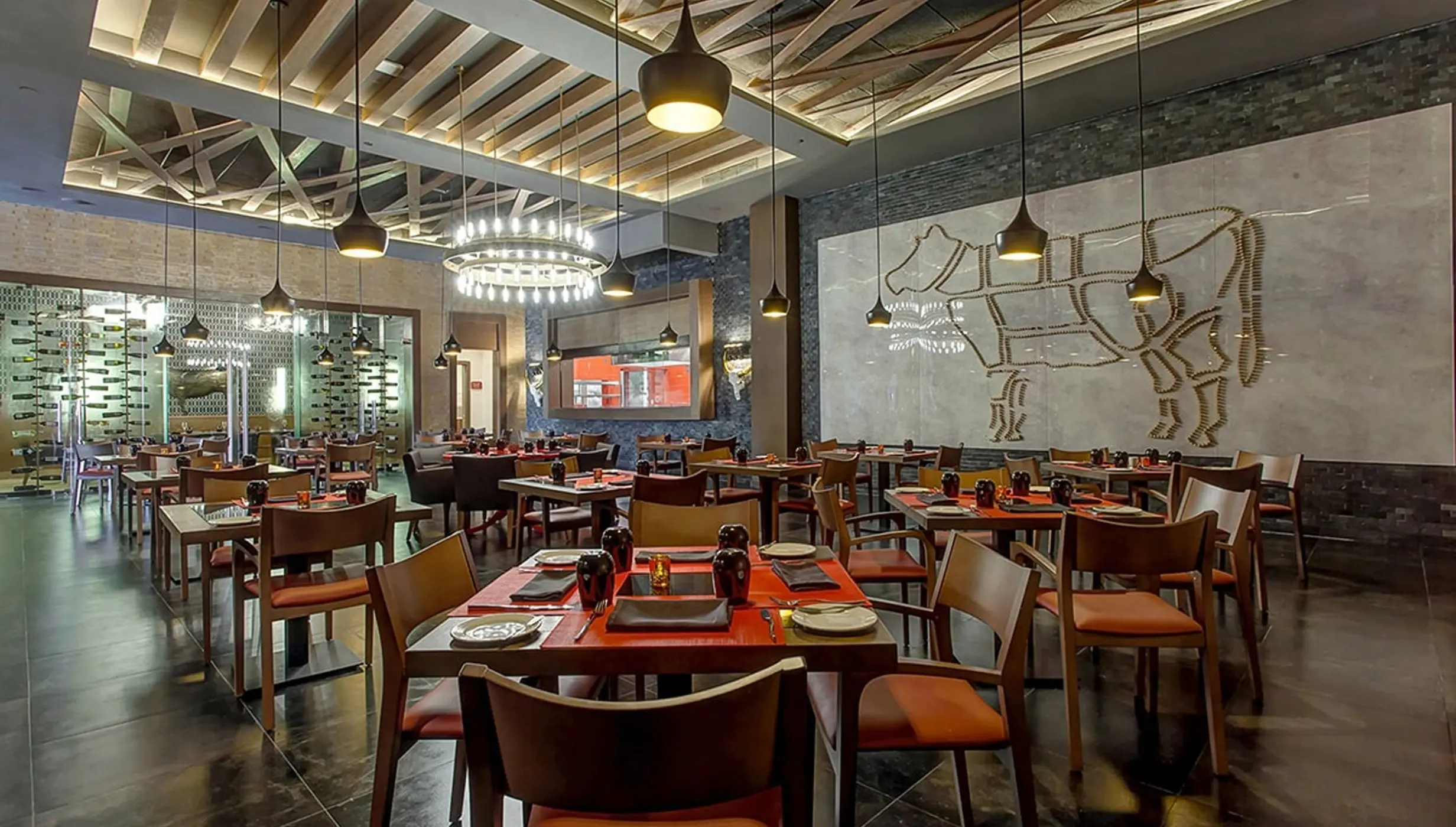 Hunter Steakhouse dining room with modern lighting and cow wall art at Royalton Bavaro, Punta Cana