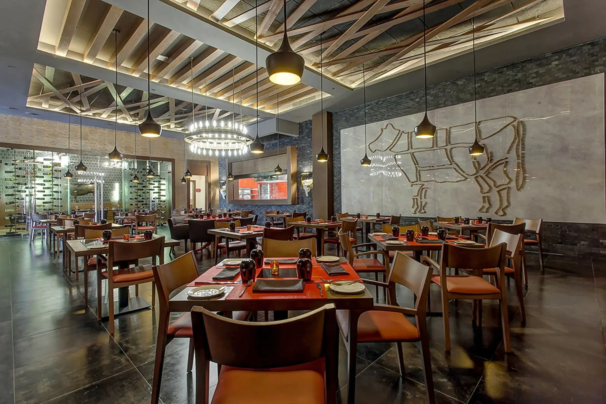 Hunter Steakhouse dining room with modern lighting and cow wall art at Royalton Bavaro, Punta Cana