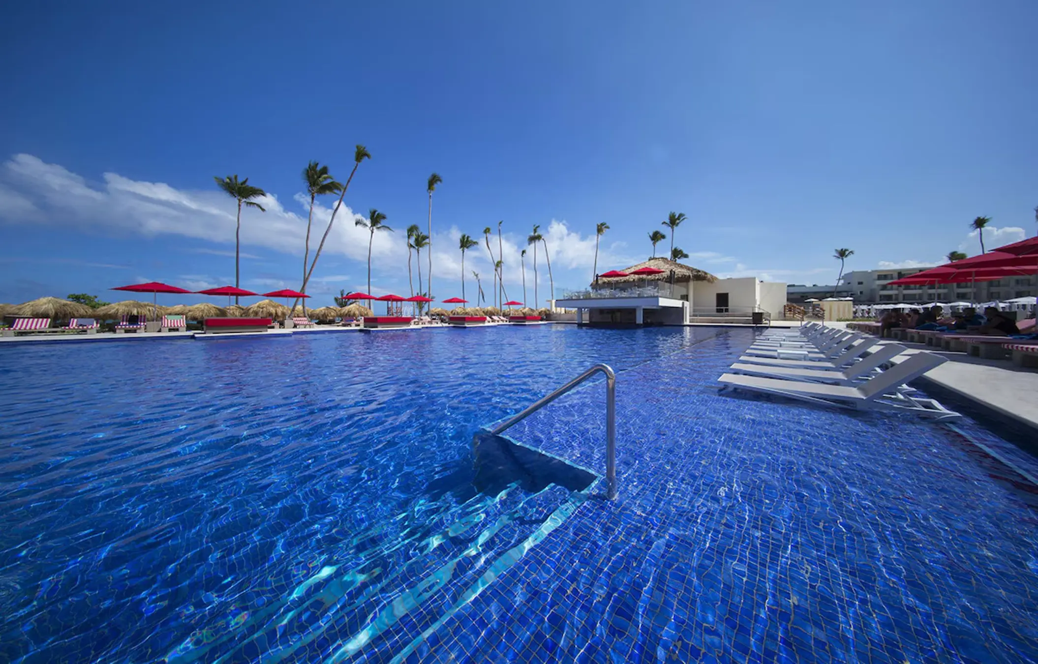Main pool with red umbrellas and lounge chairs at Royalton Bavaro, Punta Cana