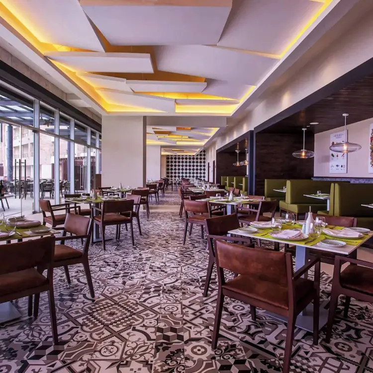 Modern restaurant interior with geometric floor tiles and floor-to-ceiling windows at Royalton Bavaro, Punta Cana