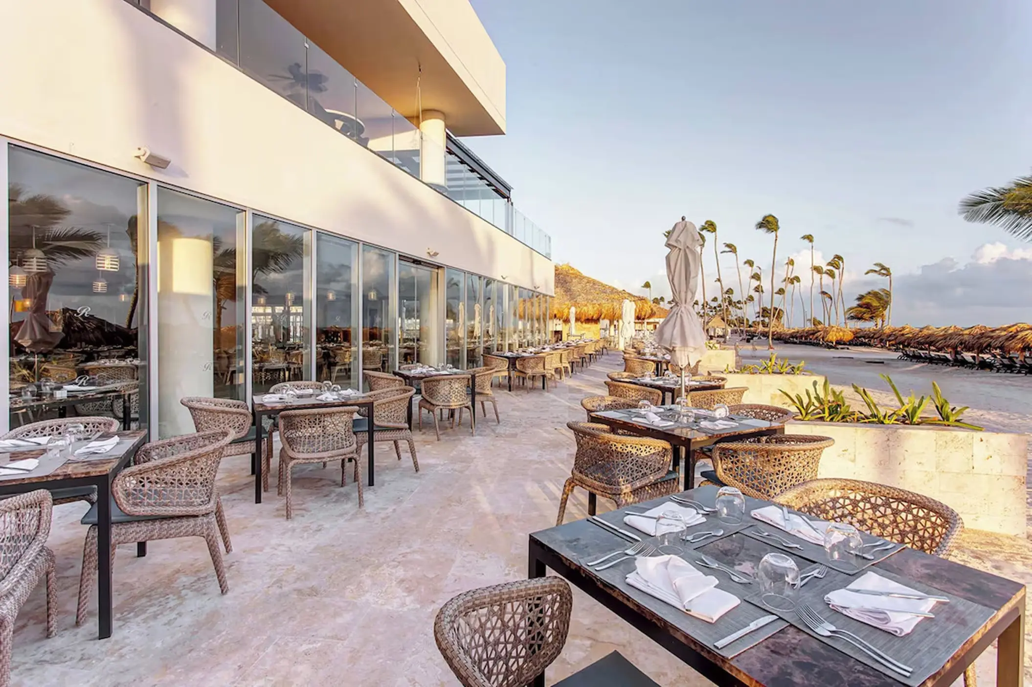 Outdoor restaurant terrace with woven chairs at Royalton Bavaro, Punta Cana