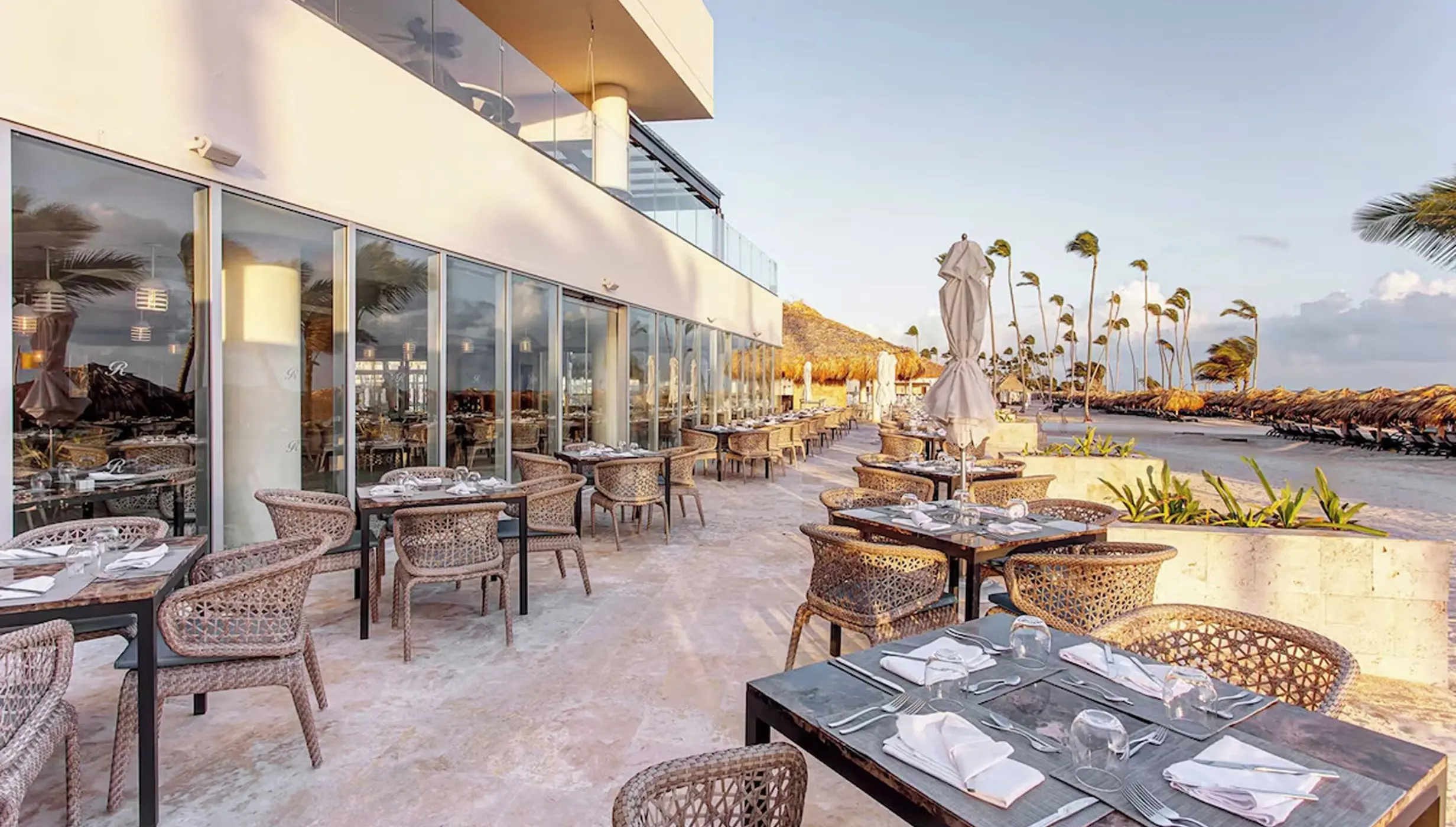 Outdoor restaurant terrace with woven chairs at Royalton Bavaro, Punta Cana