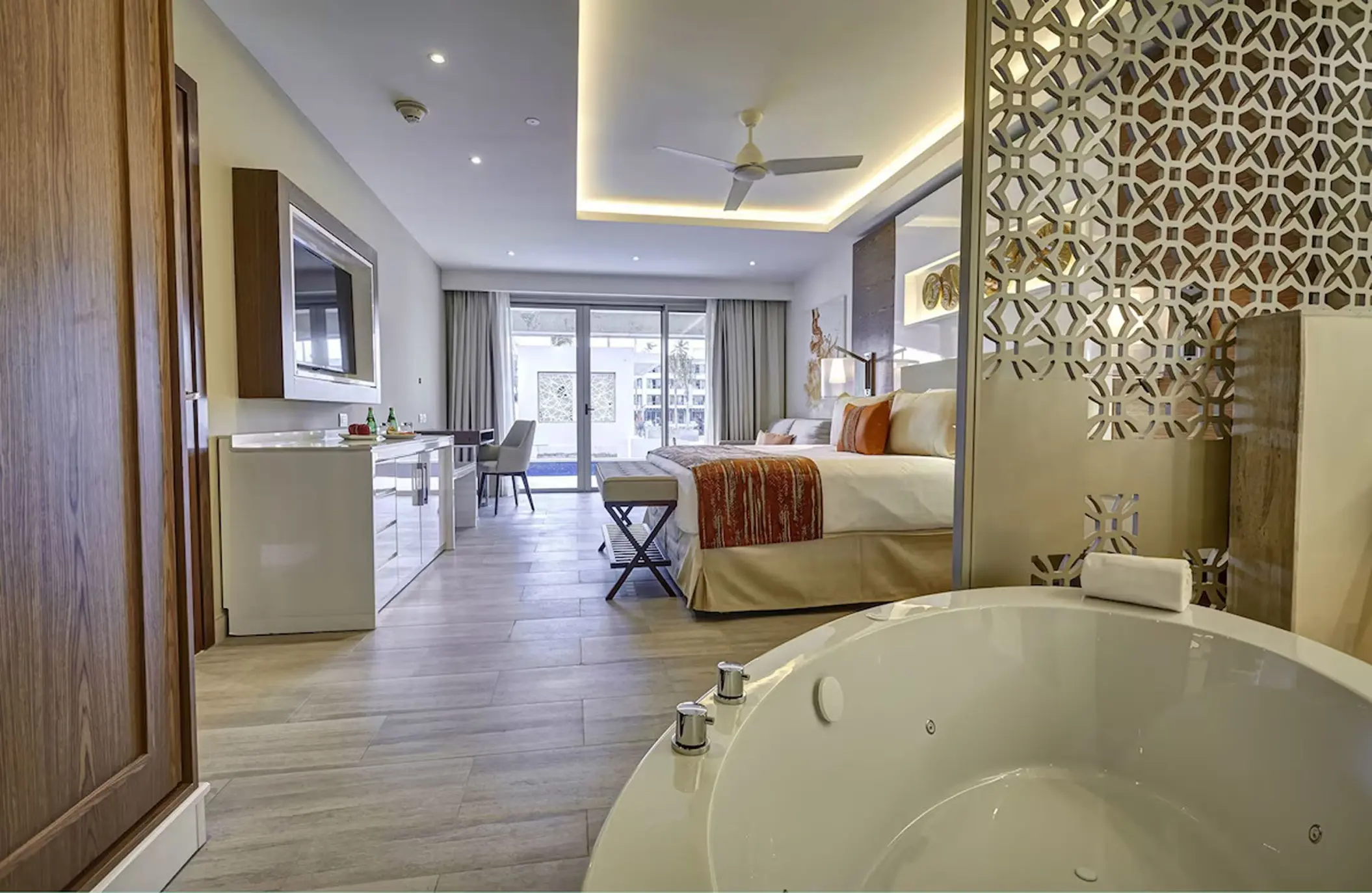 Modern suite with a white soaking tub and private balcony at Royalton Bavaro, Punta Cana