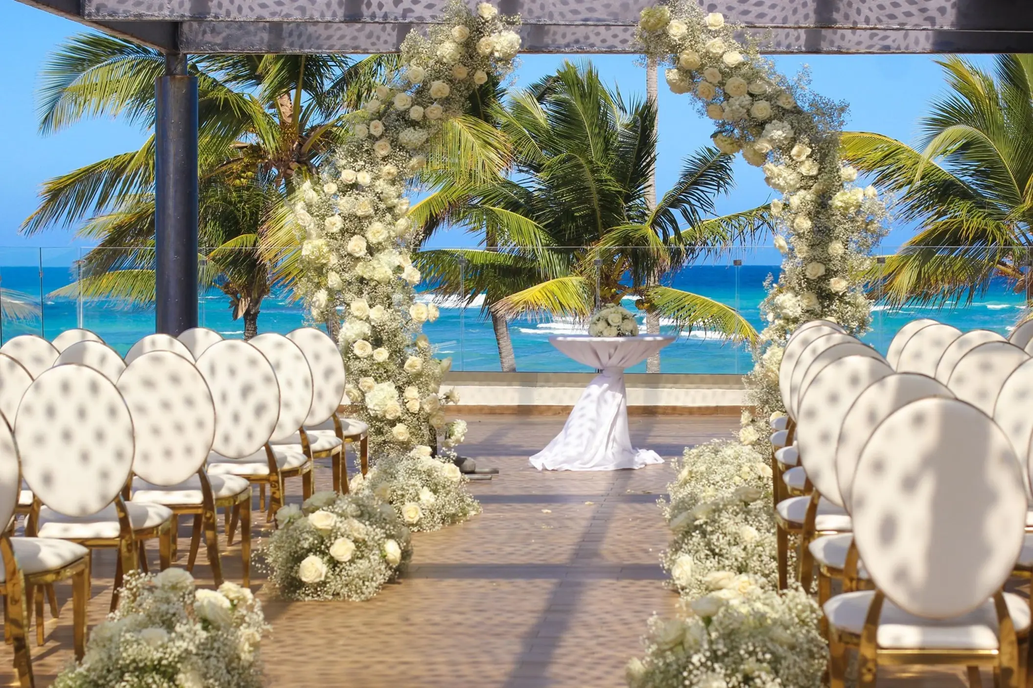 Sky Terrace wedding ceremony setup with a white flower arch at Royalton Bavaro, Punta Cana