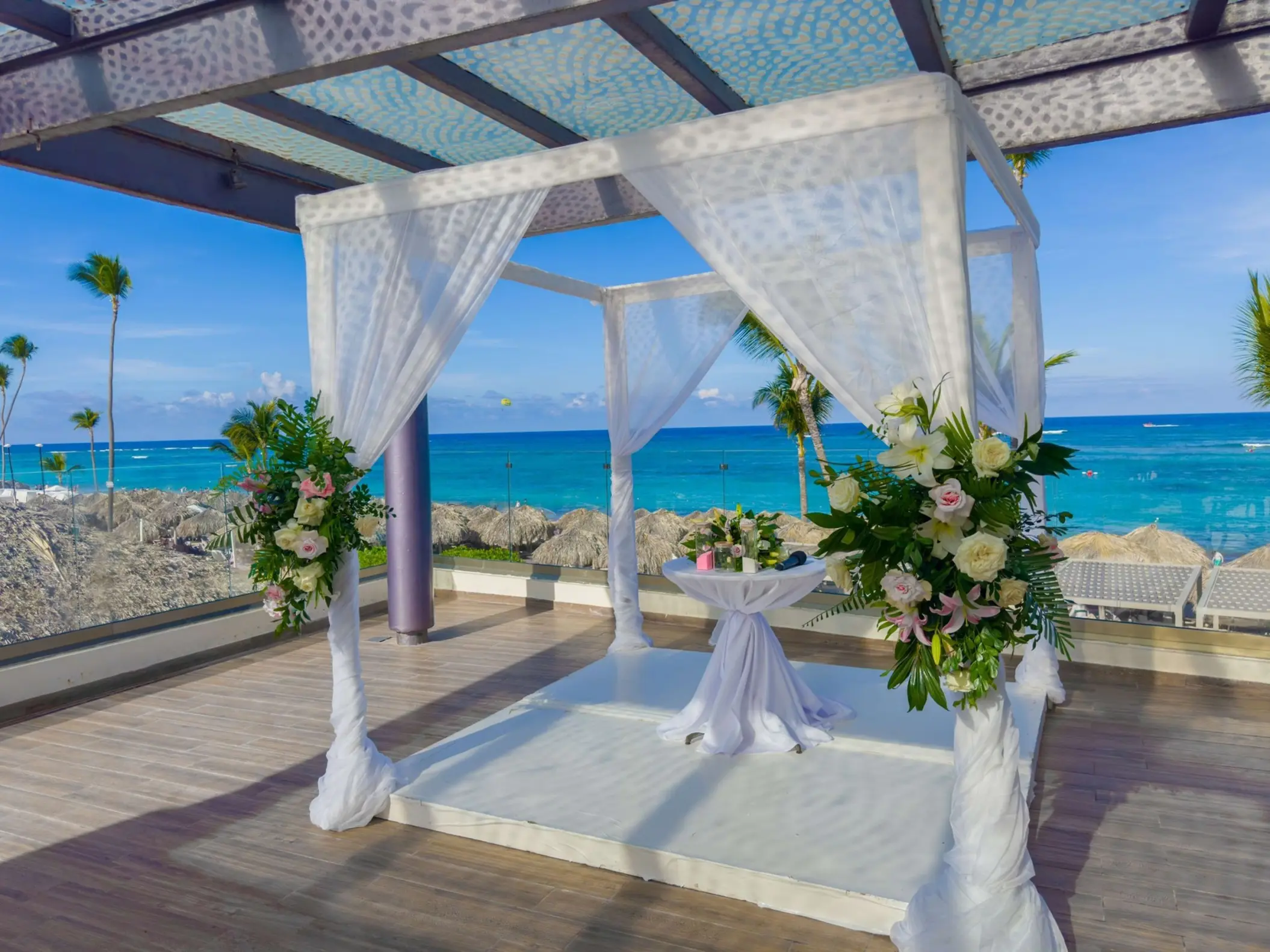 Sky terrace wedding ceremony setup with white floral arch at Royalton Bavaro, Punta Cana