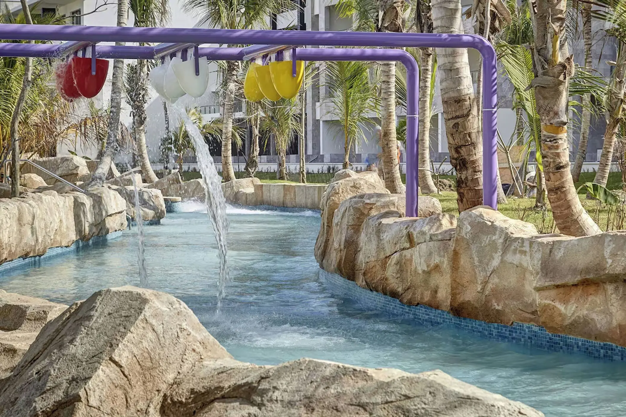 Water park splash zone with purple pipes and tipping buckets at Royalton Bavaro, Punta Cana