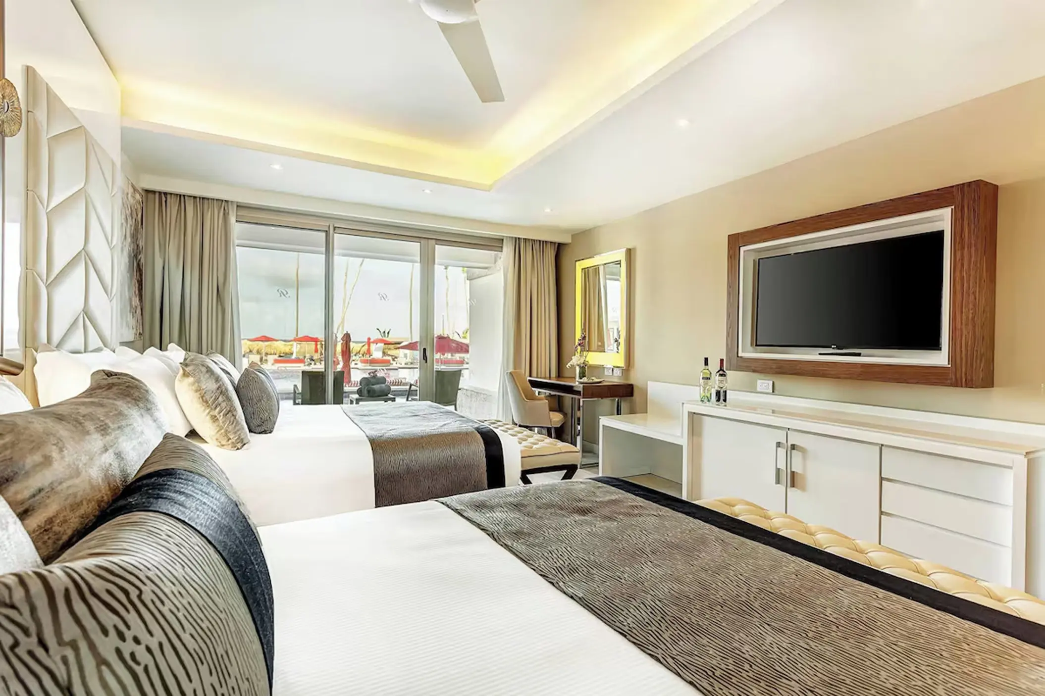 Modern hotel suite with two beds and sliding glass doors at Royalton Bavaro, Punta Cana
