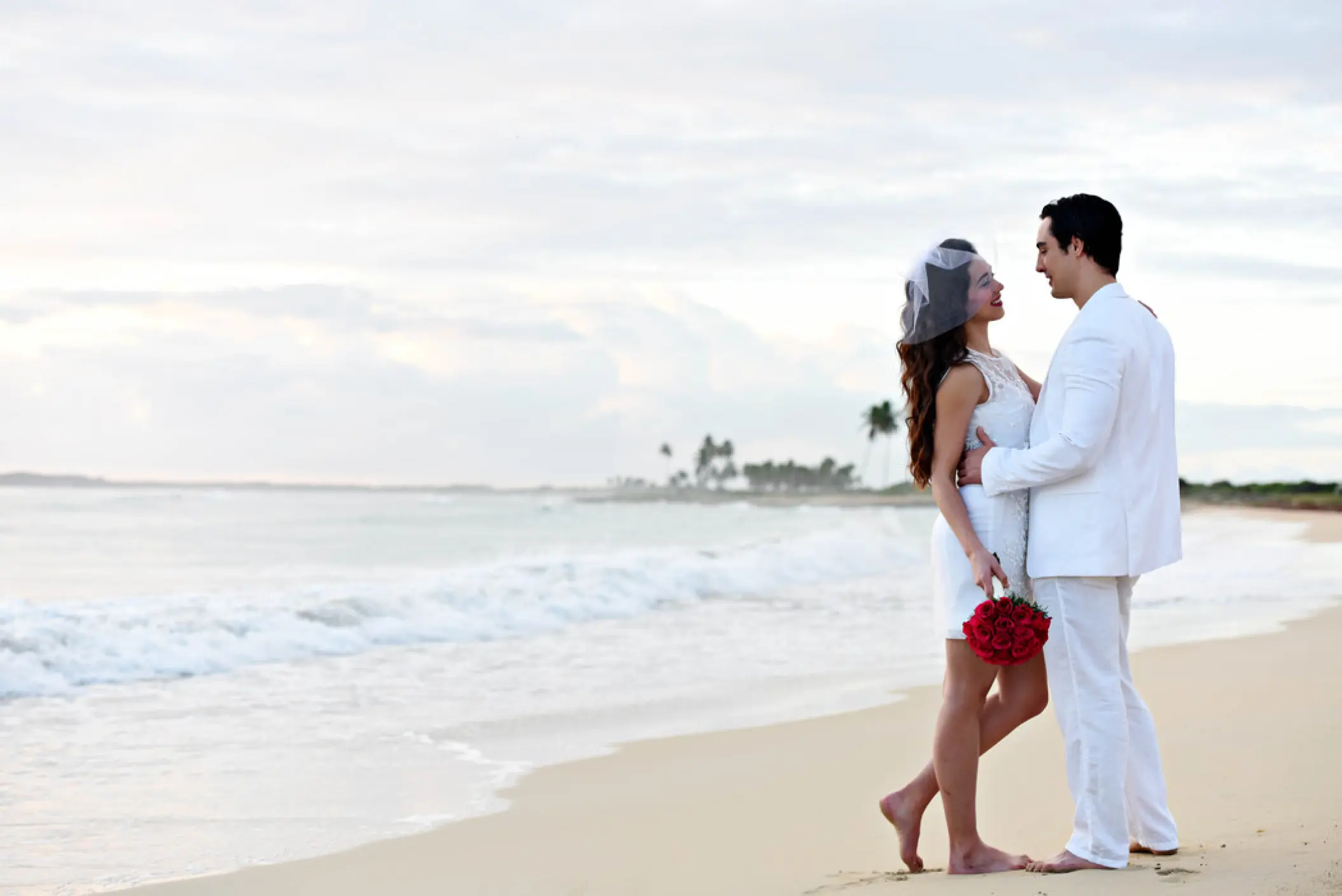 Bride and groom posing barefoot on the beach at Royalton CHIC Punta Cana