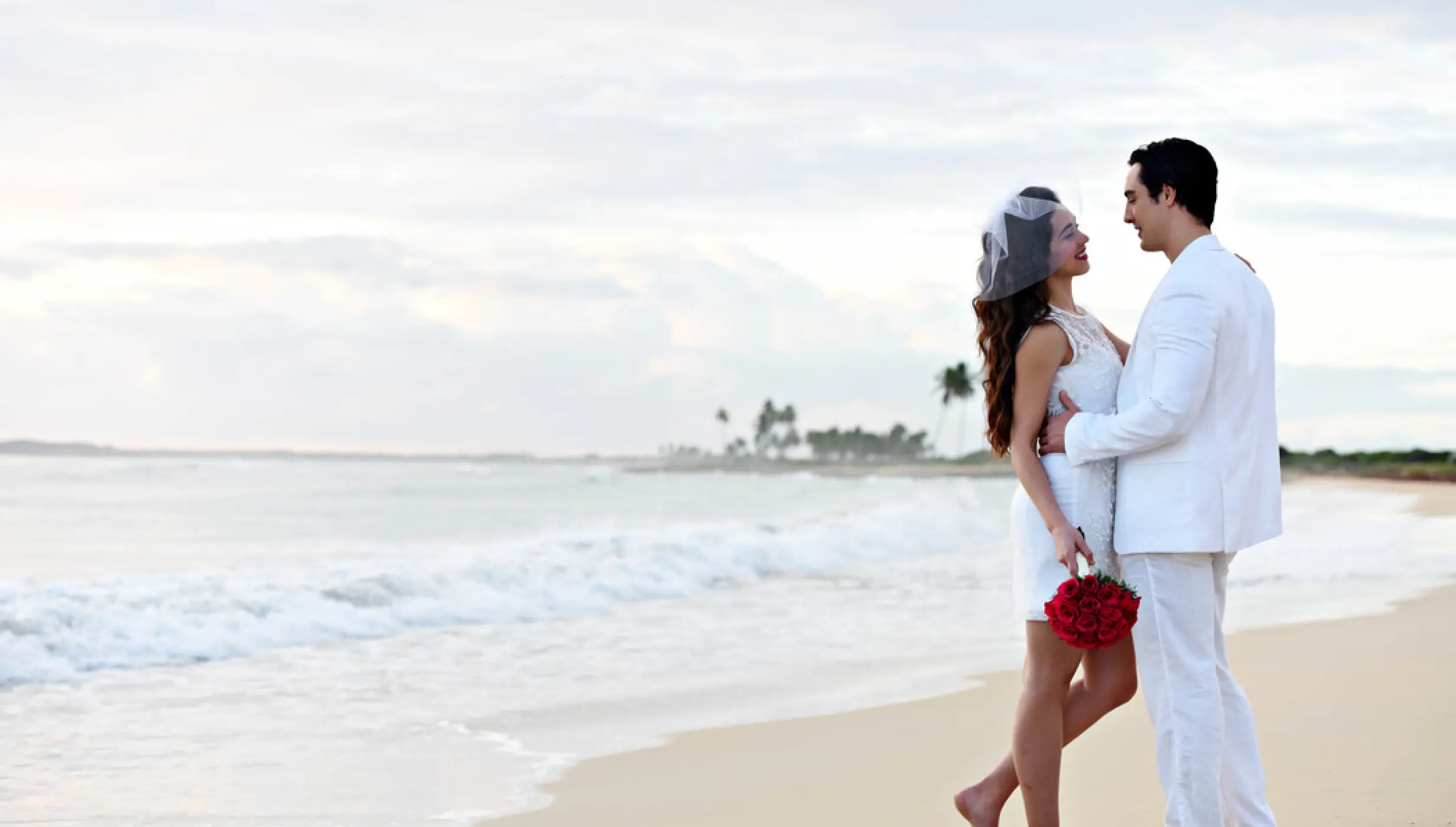 Bride and groom posing barefoot on the beach at Royalton CHIC Punta Cana