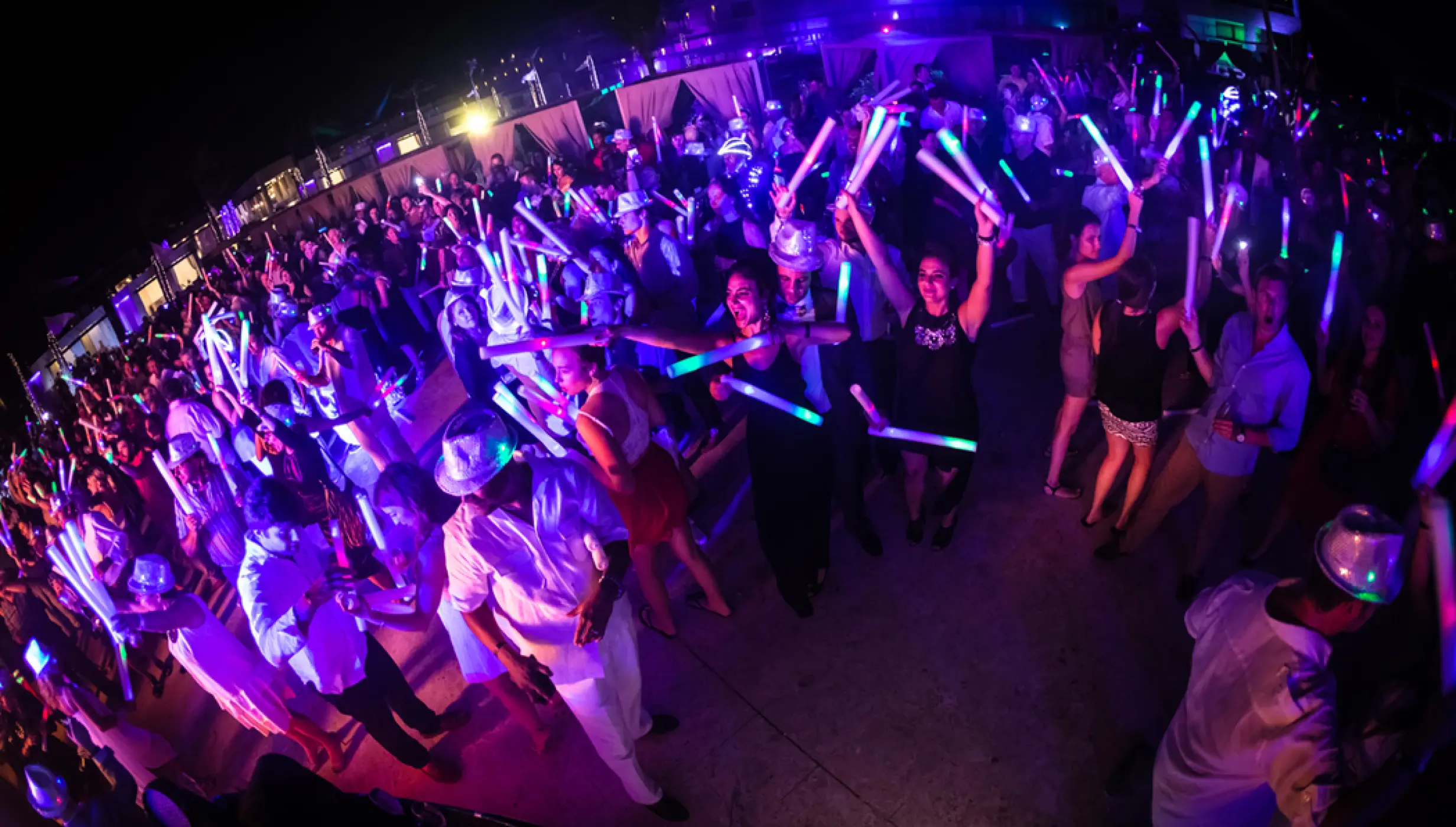 Guests dancing with glow sticks at a night party, Royalton CHIC Punta Cana