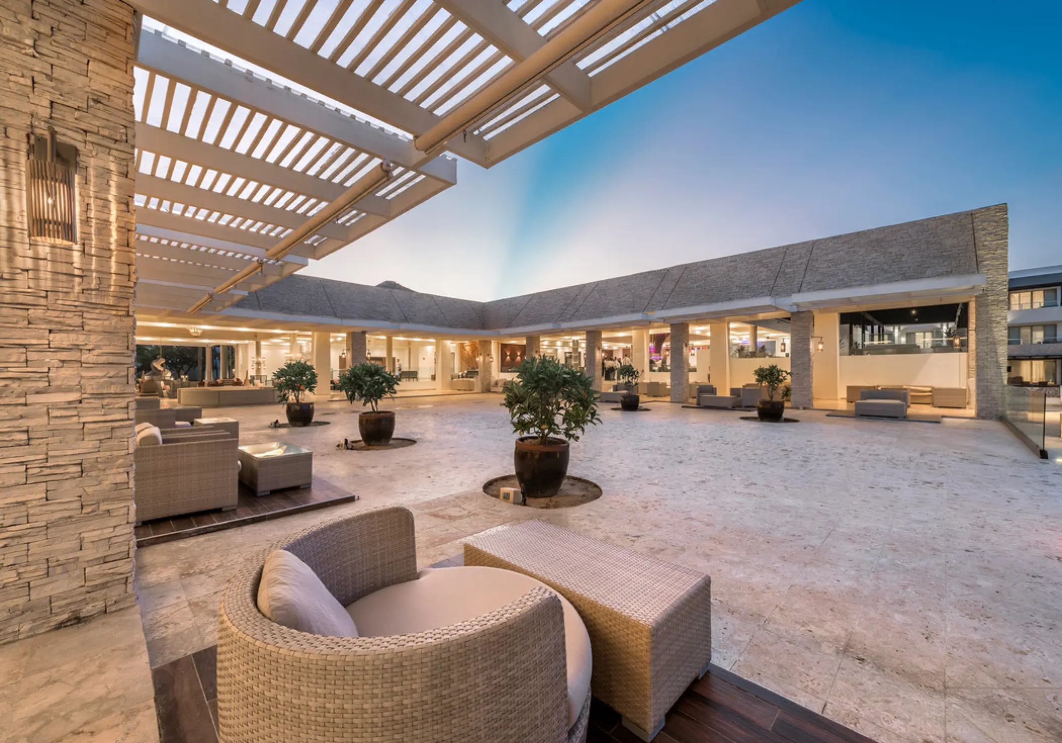Lobby terrace venue with outdoor lounge seating and potted trees at Royalton CHIC Punta Cana