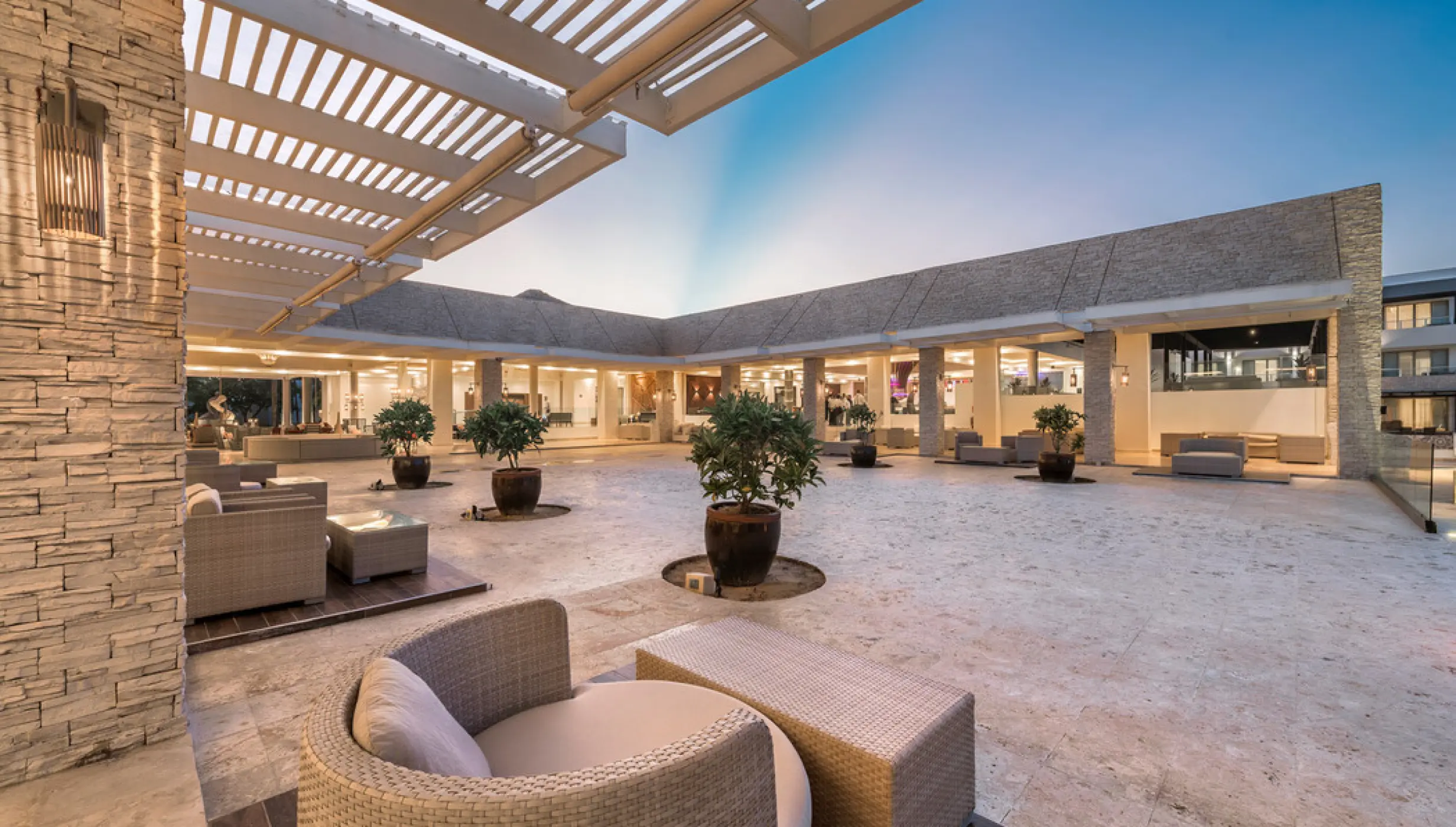 Lobby terrace venue with outdoor lounge seating and potted trees at Royalton CHIC Punta Cana