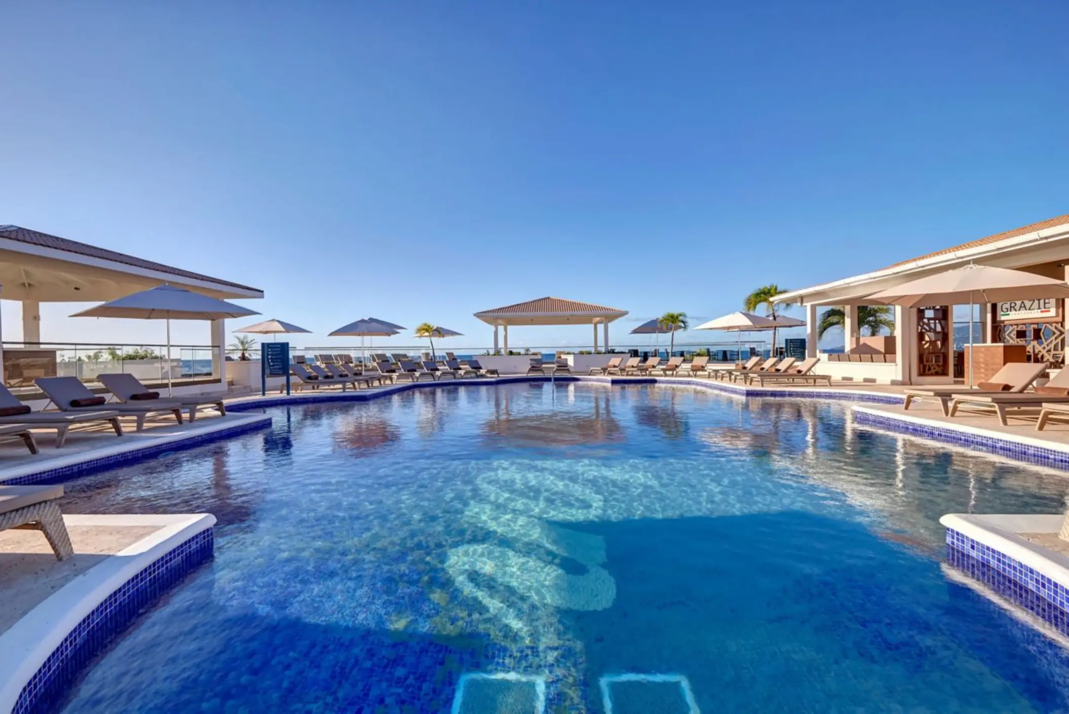 Main swimming pool with sun loungers and umbrellas at Royalton Grenada, St. George’s