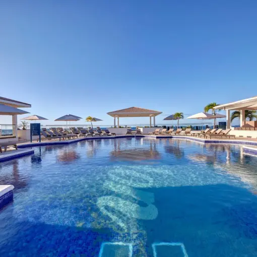 Main swimming pool with sun loungers and umbrellas at Royalton Grenada, St. George’s