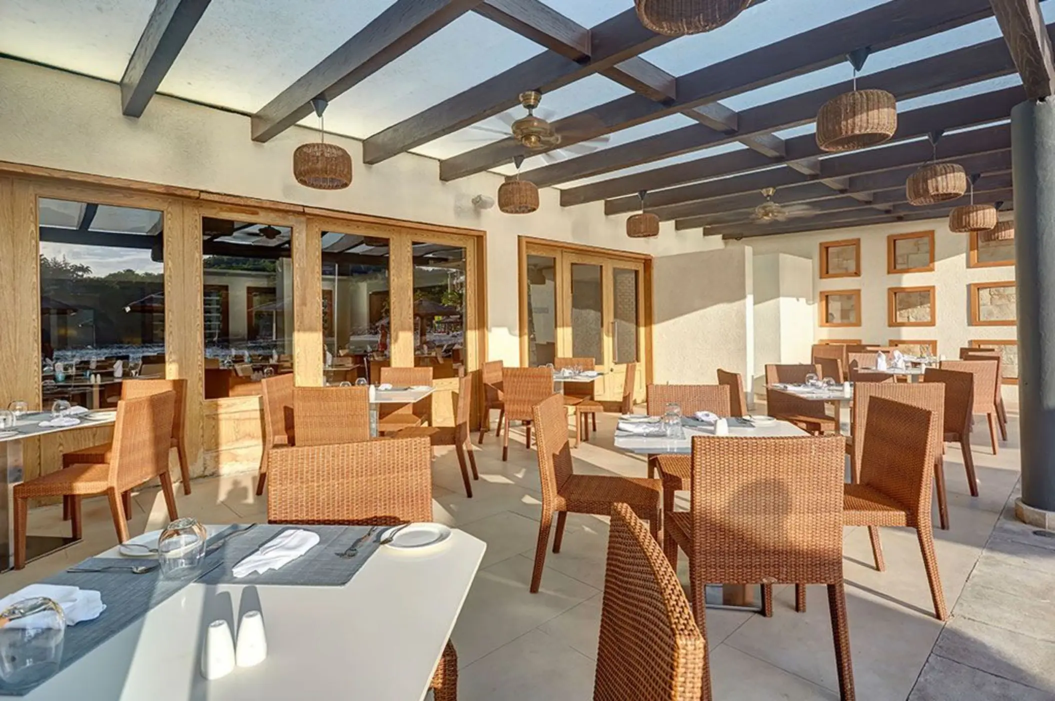 Outdoor terrace restaurant with wicker chairs under a wooden pergola at Royalton Hideaway, Castries