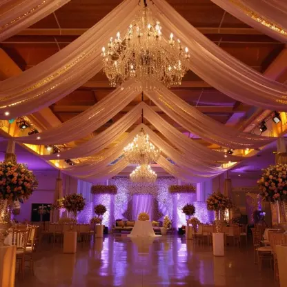 Indoor ballroom wedding reception with white ceiling drapes and chandeliers at Royalton Punta Cana, Punta Cana