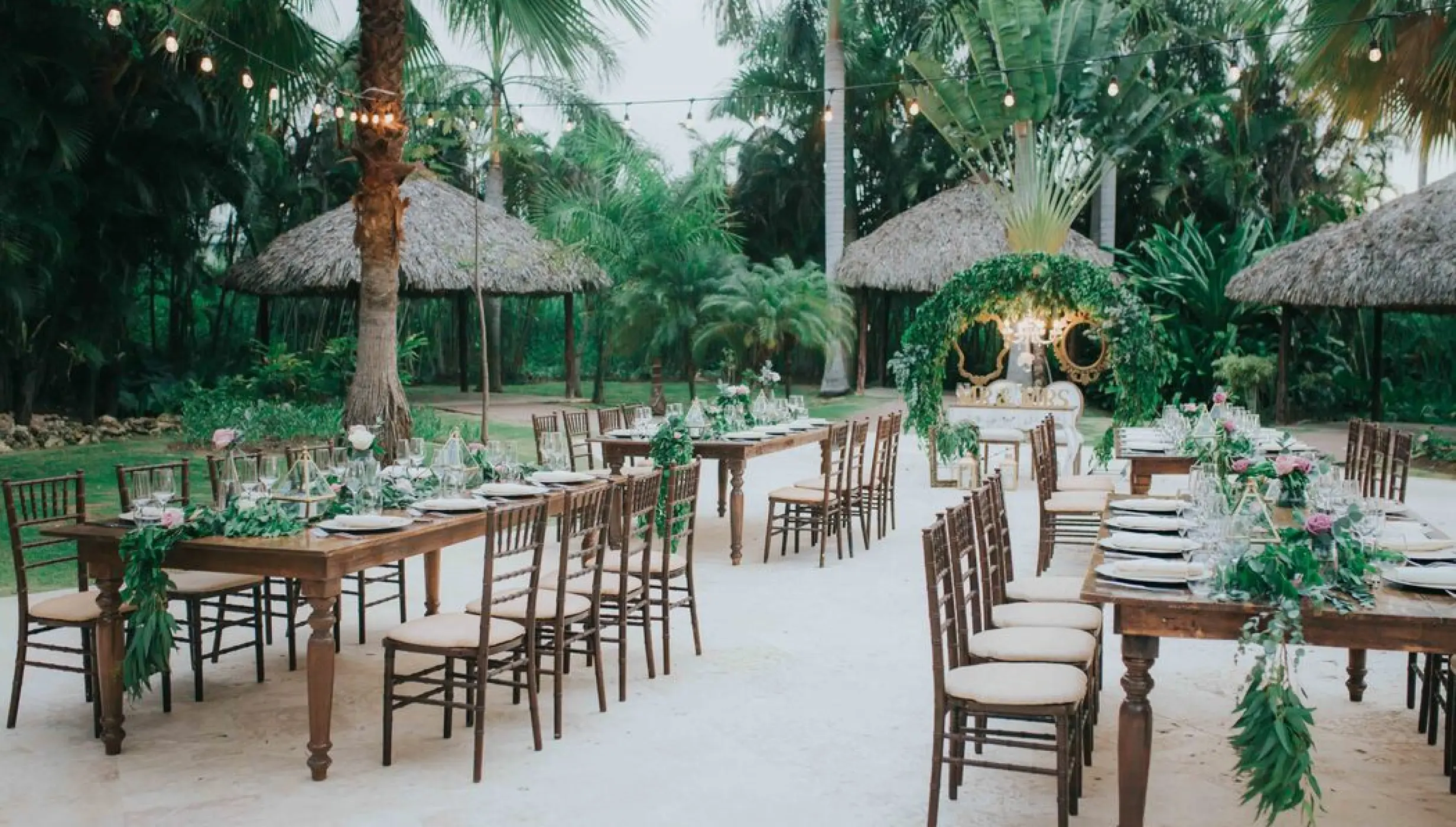 Outdoor garden wedding reception with rustic tables and string lights at Royalton Punta Cana, Punta Cana