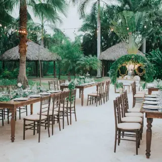 Outdoor garden wedding reception with rustic tables and string lights at Royalton Punta Cana, Punta Cana