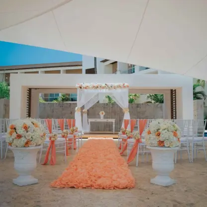 Plaza gazebo wedding ceremony with orange aisle runner and white chairs at Royalton Punta Cana, Punta Cana
