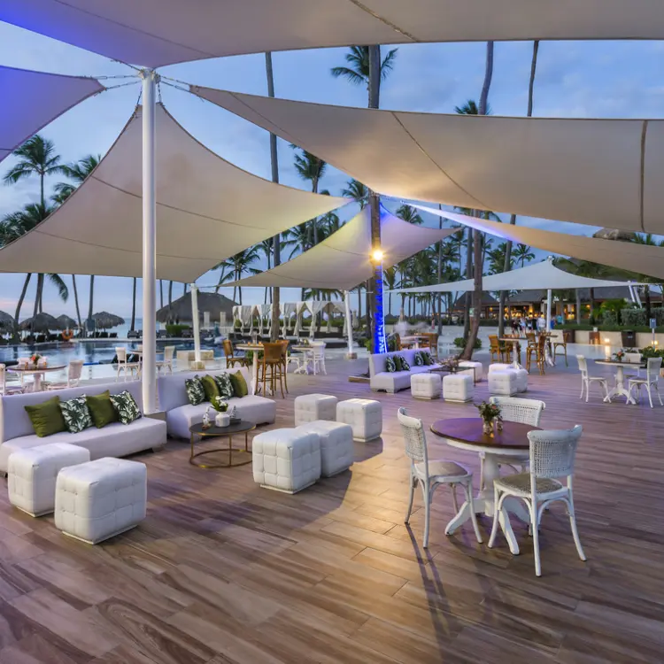 Outdoor lounge and restaurant with white sail canopies at Royalton Punta Cana
