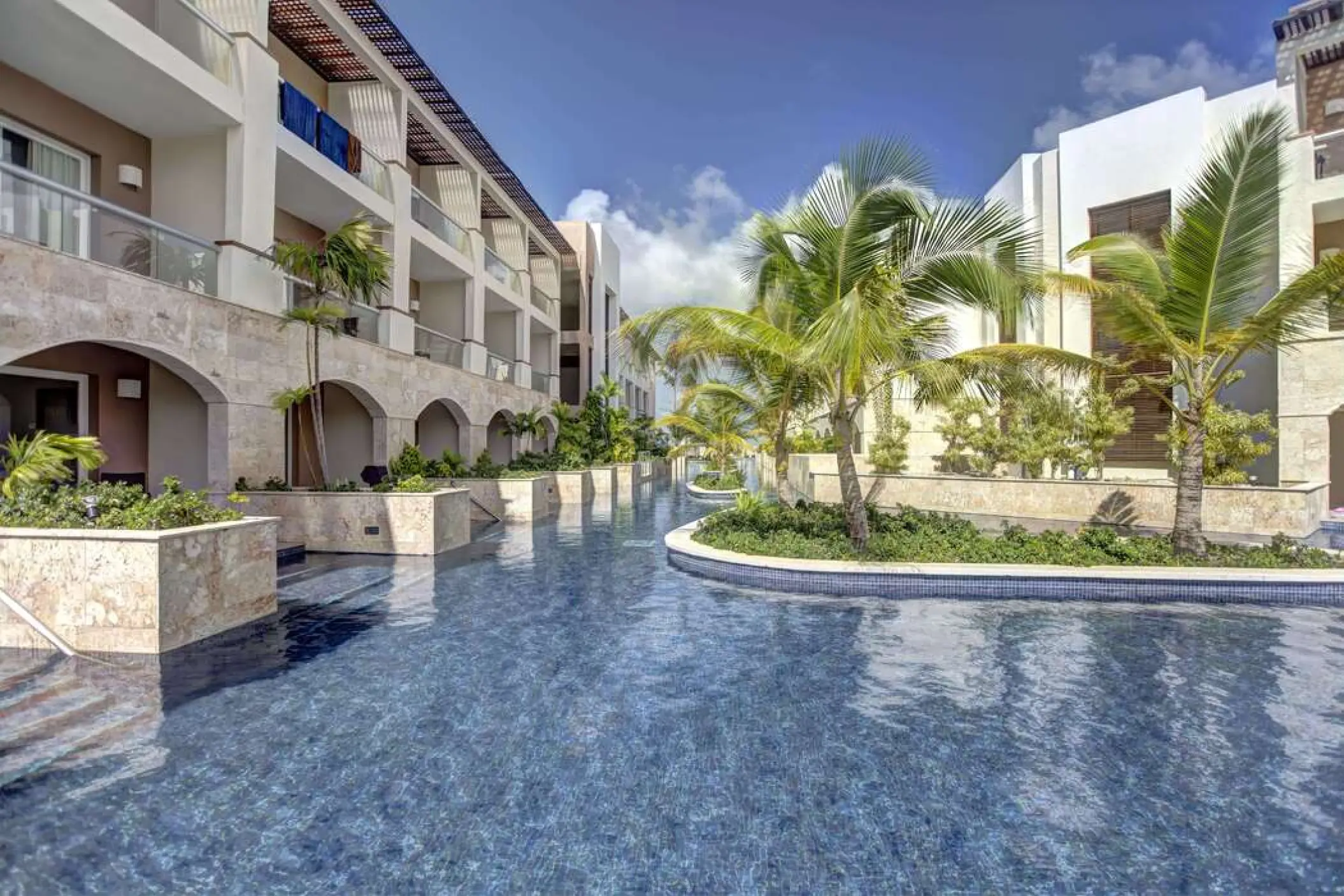 Swim-out suites and pool surrounded by palm trees at Royalton Punta Cana