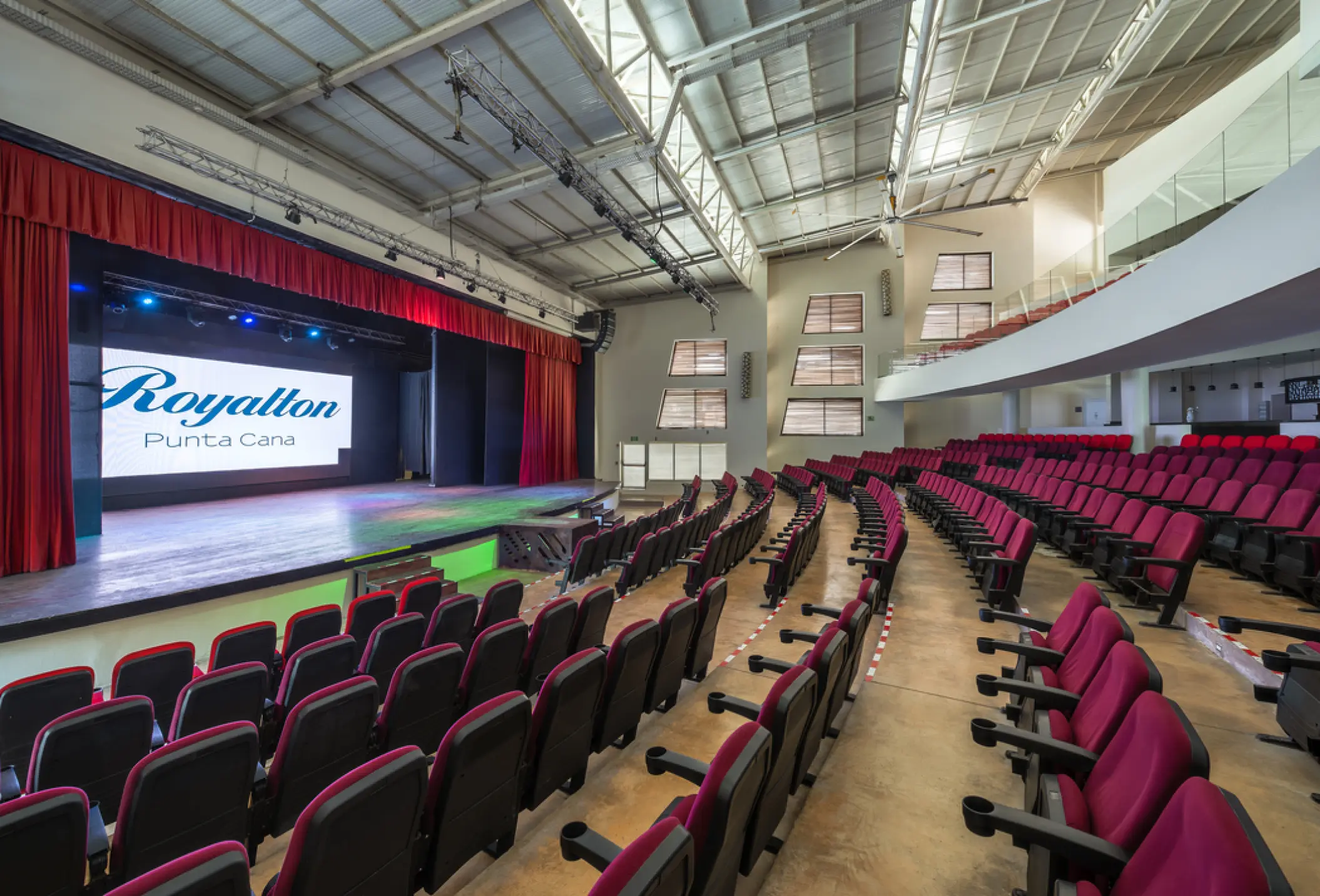 Indoor theater with tiered red seating and a stage at Royalton Punta Cana, Punta Cana