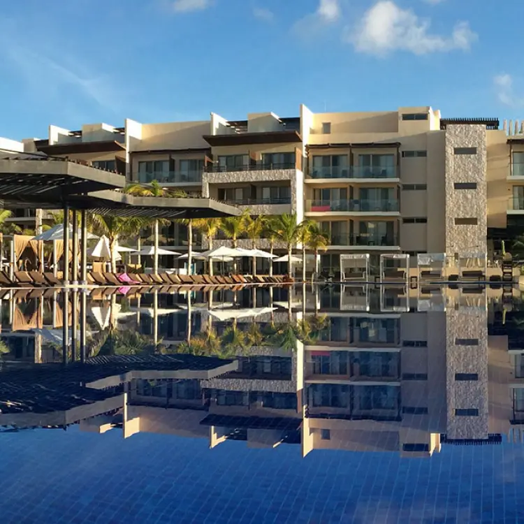 Modern resort buildings reflected in the main swimming pool at Royalton Riviera Cancun, Cancun