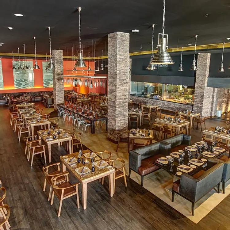 Hunter Steakhouse dining room with stone pillars and industrial lighting at Royalton Riviera Cancun