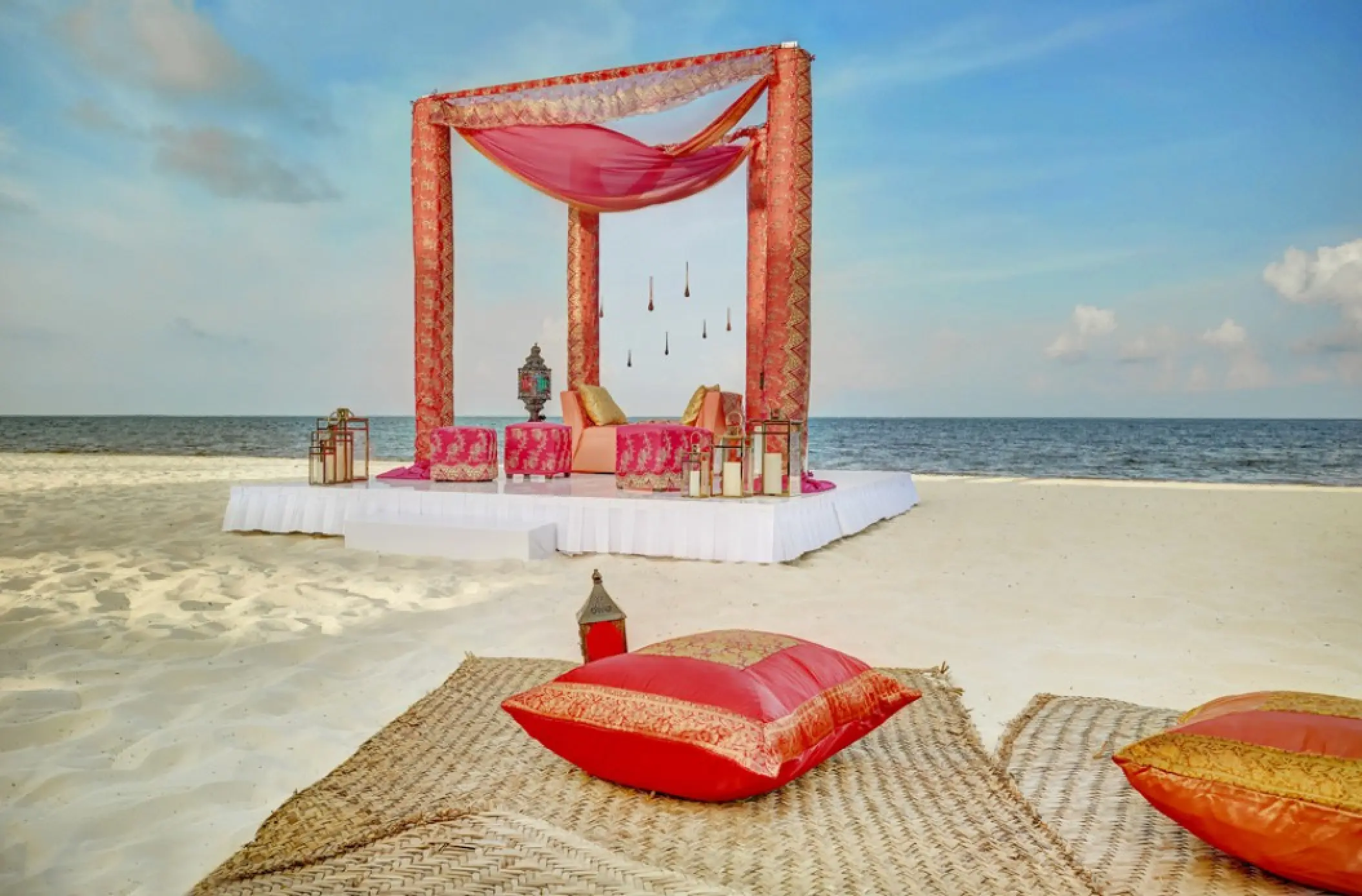 South Asian beach wedding mandap with pink and gold fabrics at Royalton Riviera Cancun