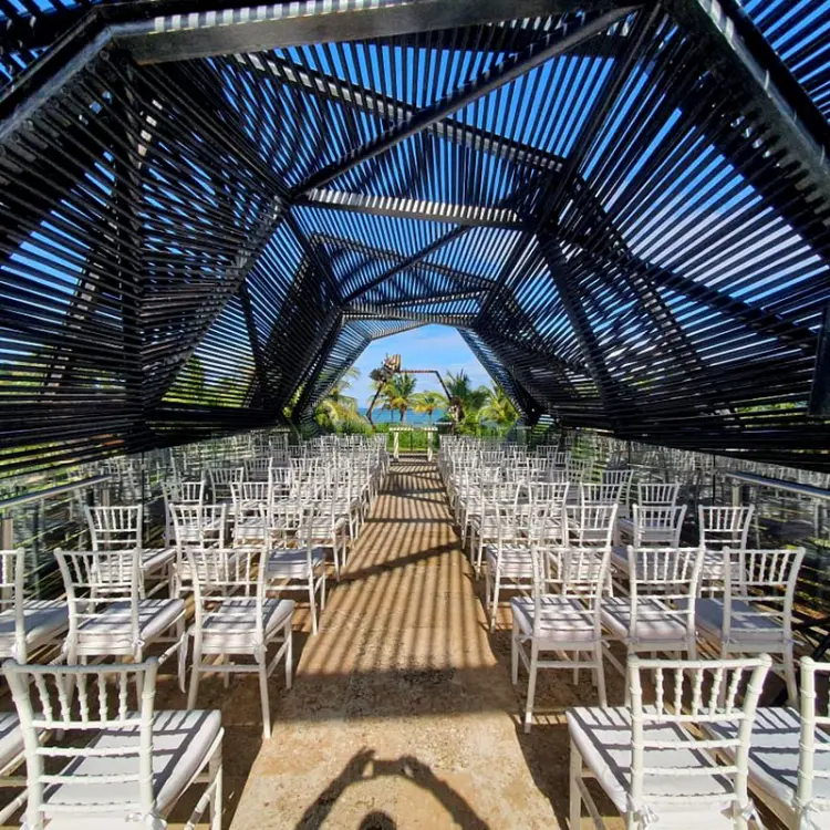 Sky wedding ceremony setup with white chairs and a slatted wood roof at Royalton Riviera Cancun