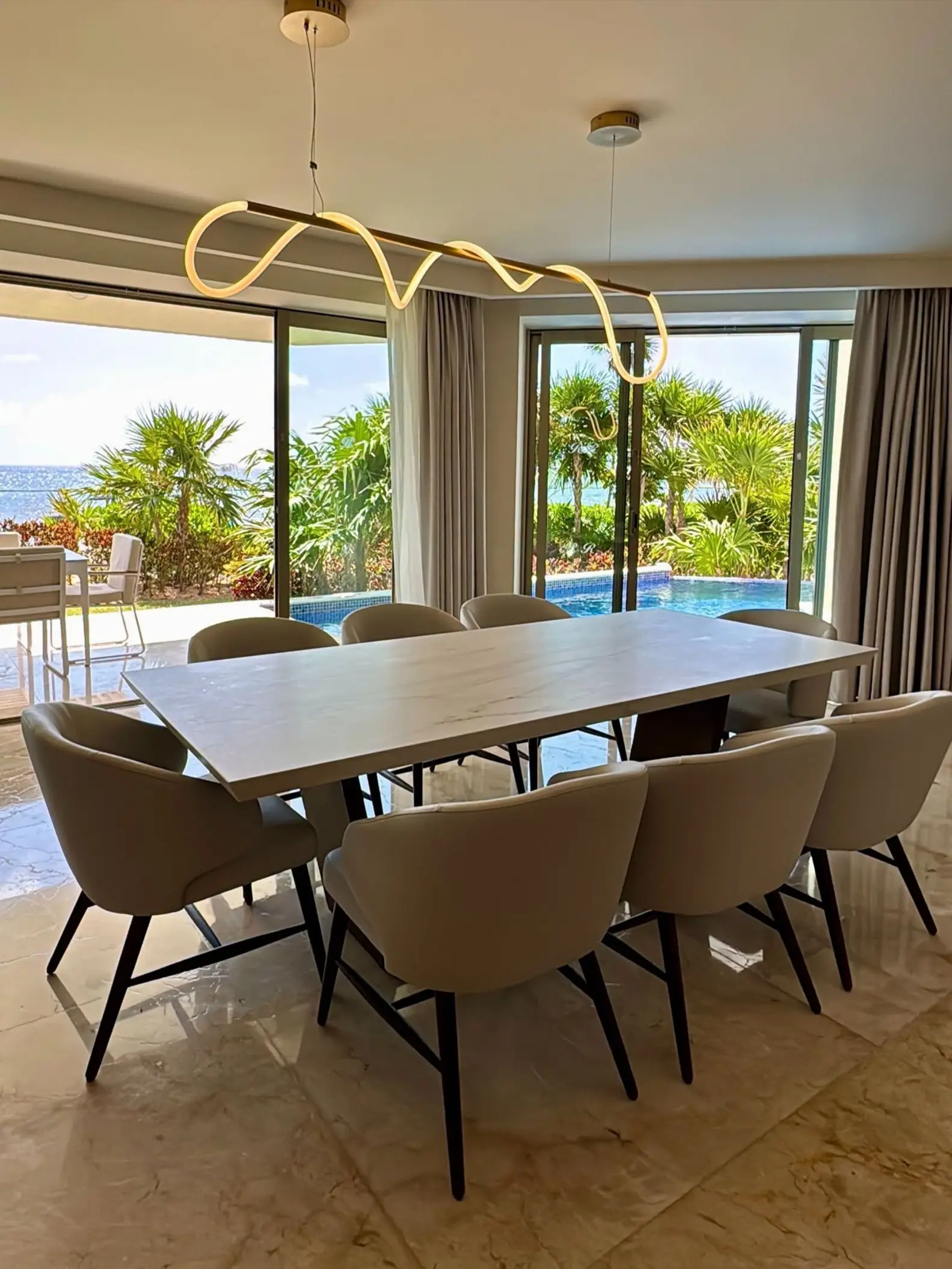 Modern suite dining area at Royalton Riviera Cancun overlooking the pool and tropical grounds, Cancun
