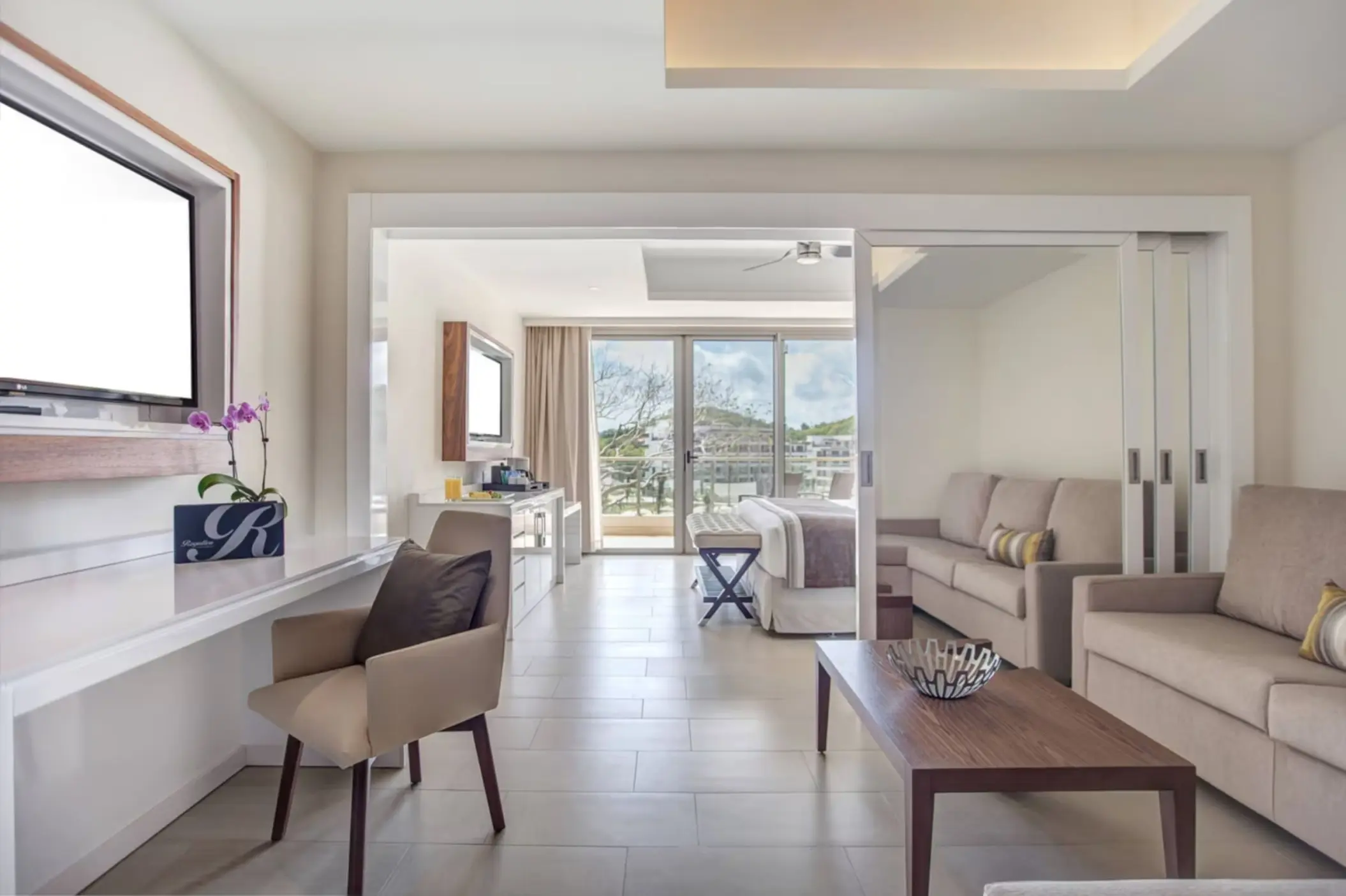 Family suite living room with neutral tones and sliding glass doors at Royalton Saint Lucia, Castries