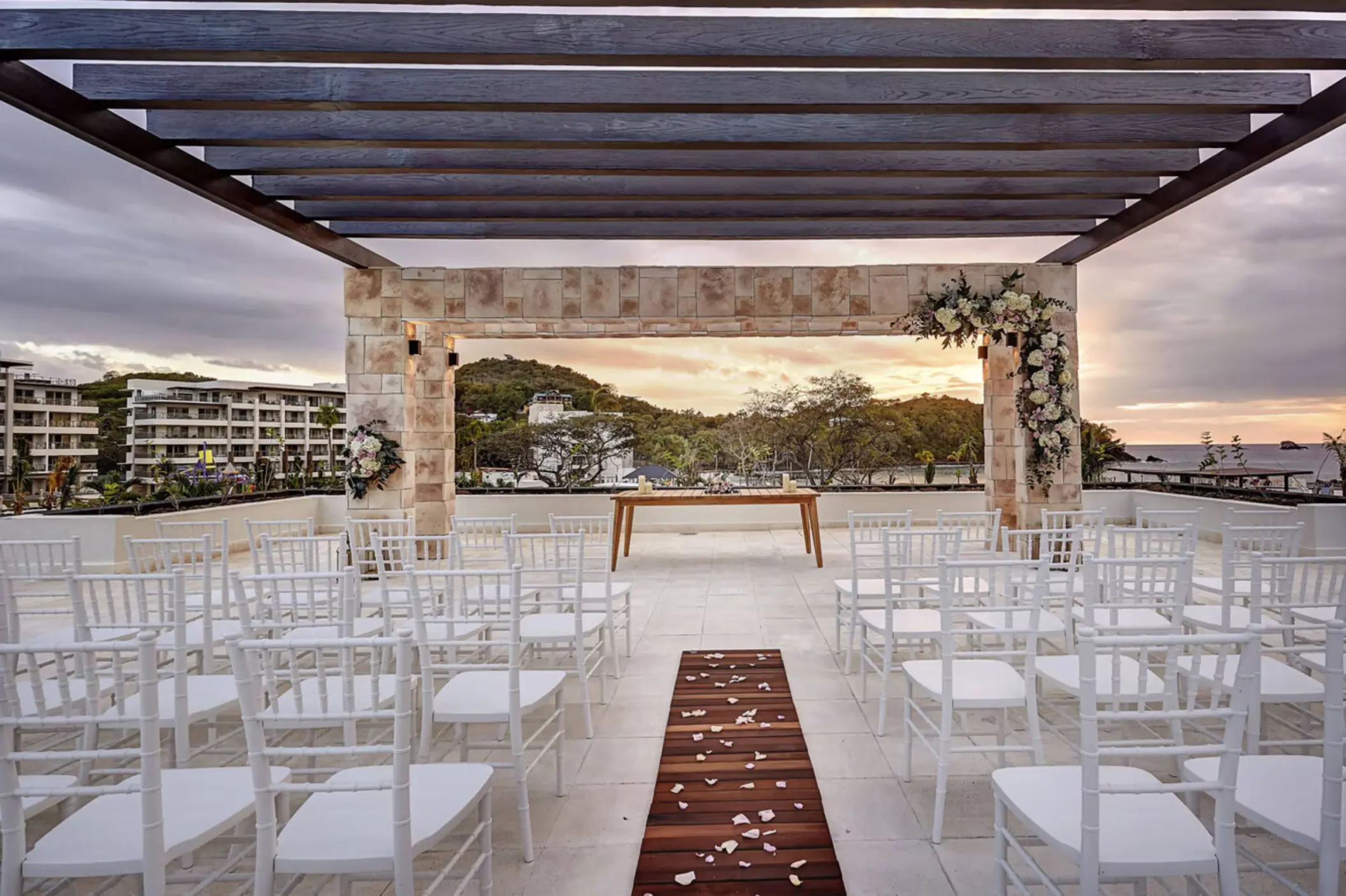 Sky terrace wedding ceremony with white chairs and floral arch at Royalton Saint Lucia, Castries