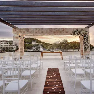 Sky terrace wedding ceremony with white chairs and floral arch at Royalton Saint Lucia, Castries