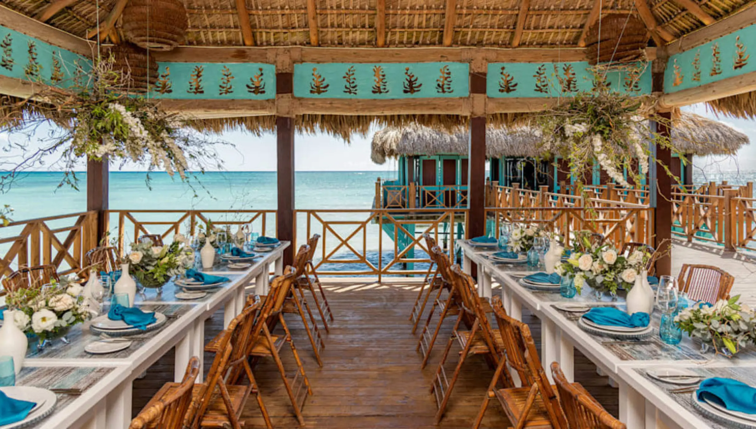 Blue Marlin wedding reception setup under a thatched portico at Sanctuary Cap Cana, Punta Cana