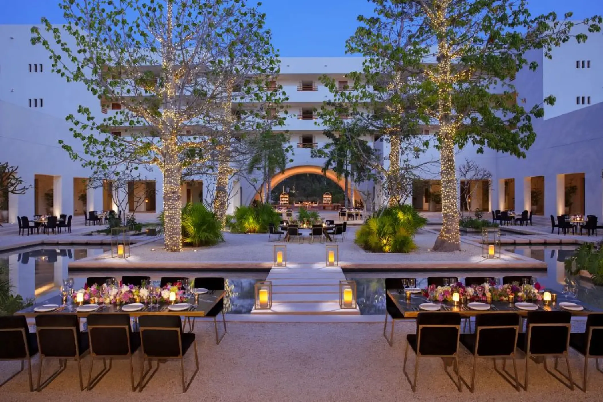 Courtyard wedding reception setup with fairy lights and lanterns at Secrets Akumal, Riviera Maya