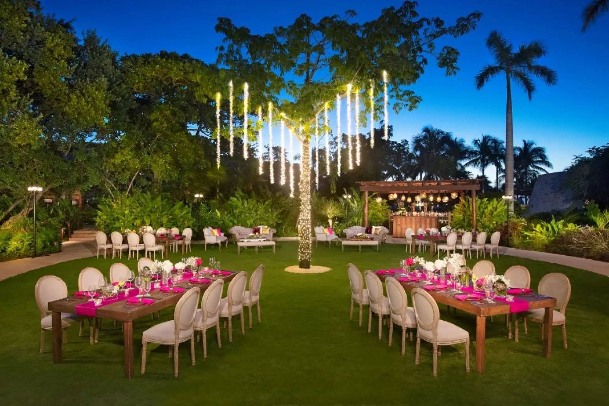 Evening wedding reception on a lawn with hanging tree lights at Secrets Akumal, Riviera Maya