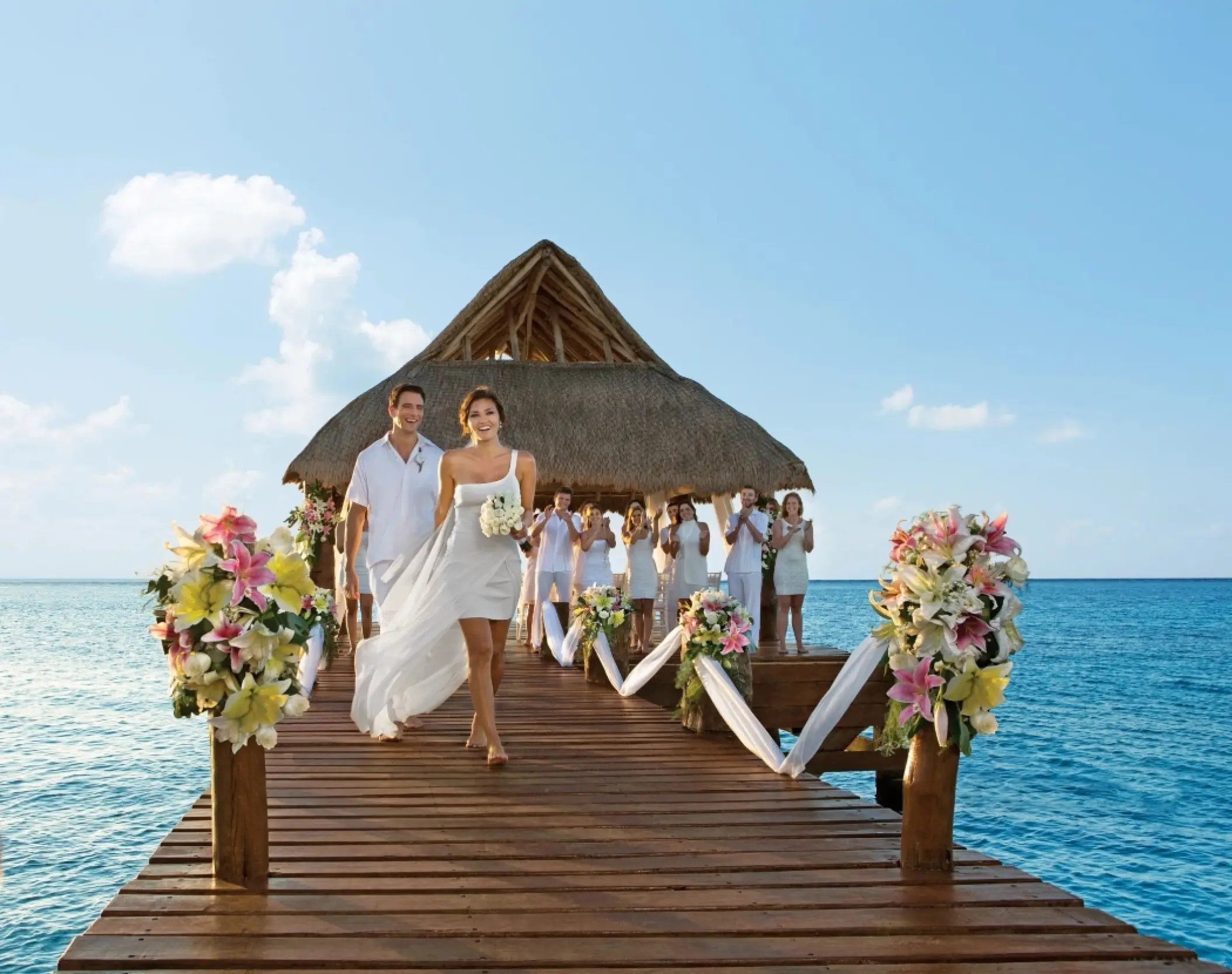 Bride and groom walking down a pier wedding ceremony venue at Secrets Aura Cozumel