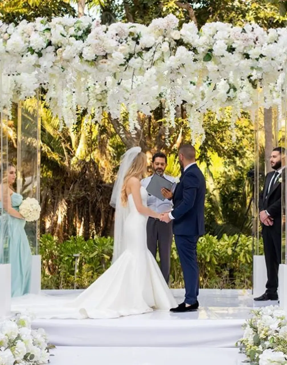 Wedding ceremony under a white floral arch at Secrets Bahia Mita, Puerto Vallarta