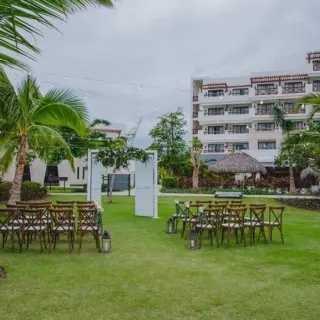 Garden wedding ceremony setup with white doors and wooden chairs at Secrets Cap Cana, Punta Cana